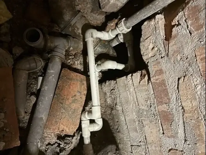 Rura kanalizacyjna odsłonięta w murze — DobryHydraulik Warszawa
